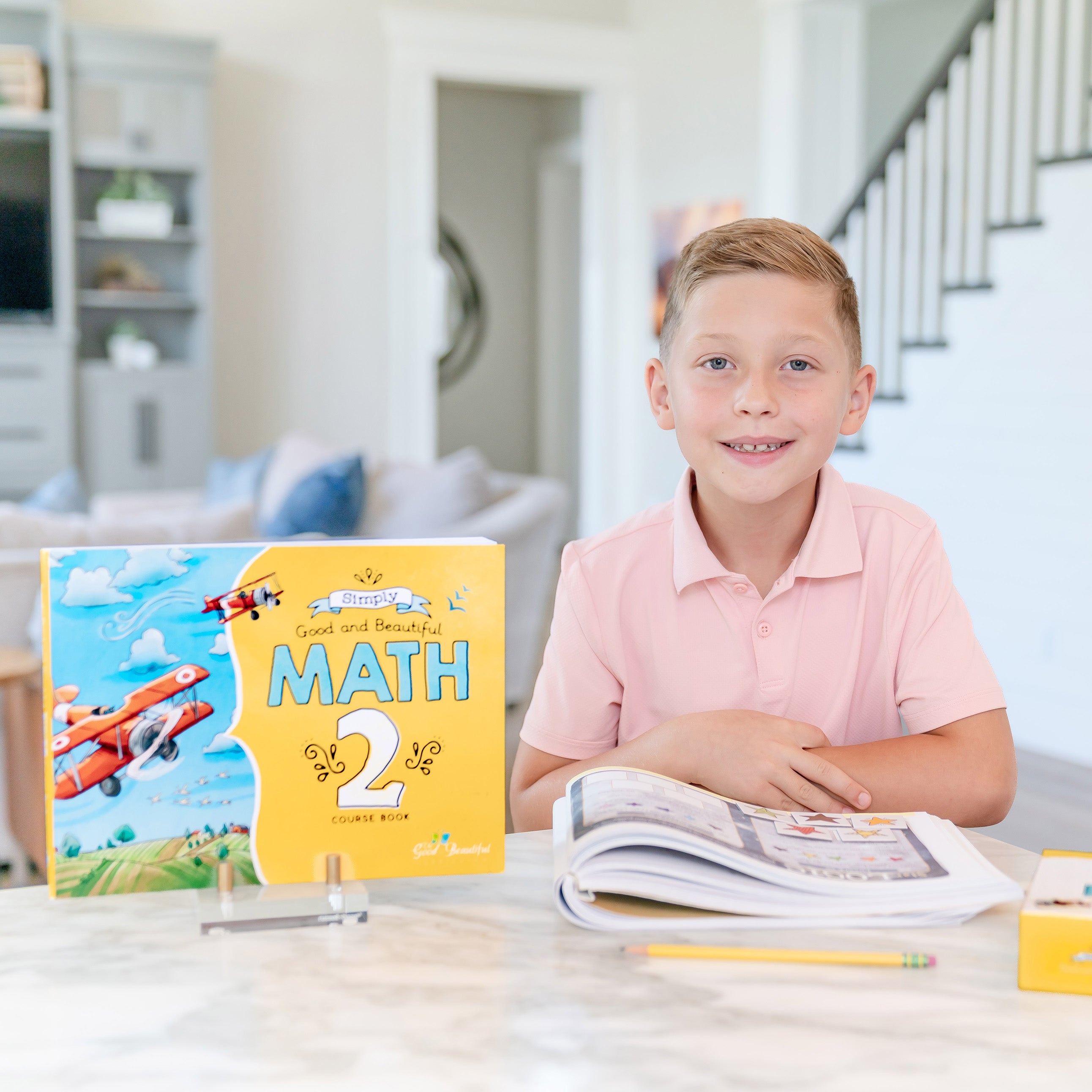 Young boy sitting at a table working on Simply Good and Beautiful Math 2 | The Good and the Beautiful