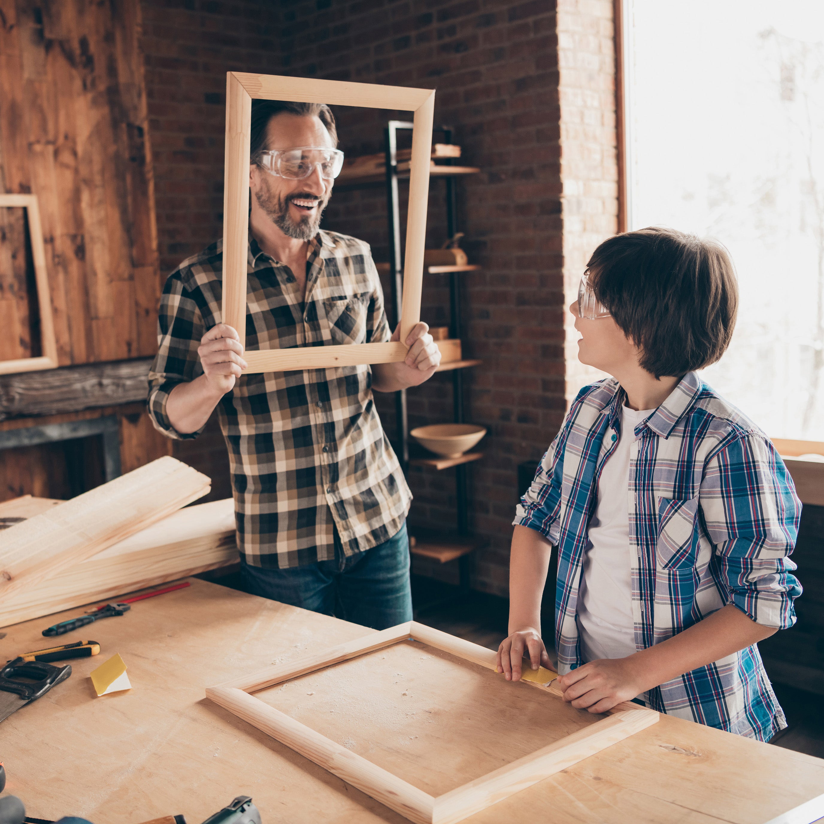 Father and son working together on a woodworking project in a workshop.