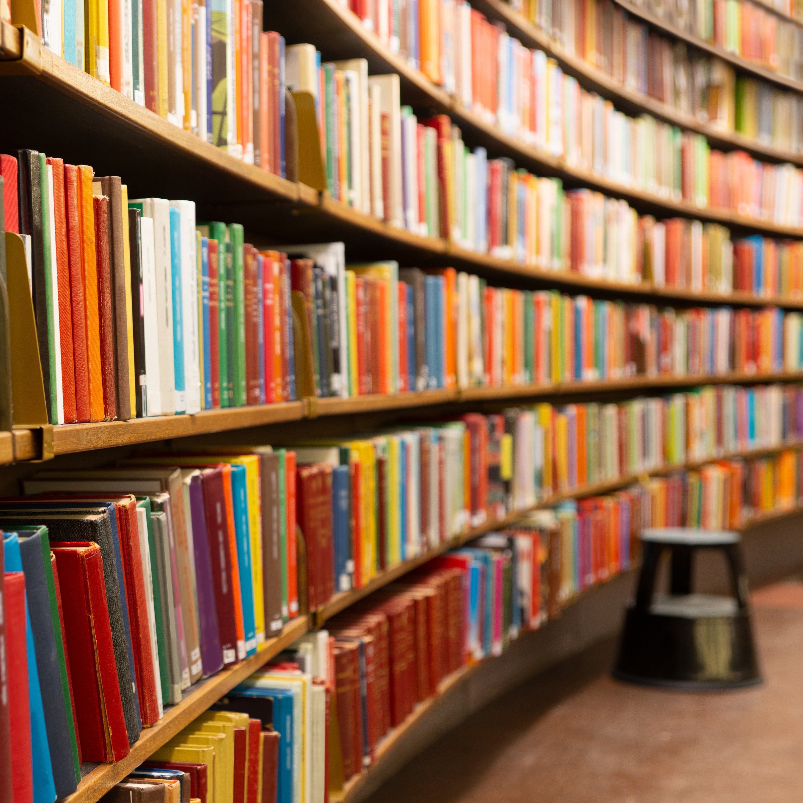 Curved library shelves filled with books | The Good and the Beautiful