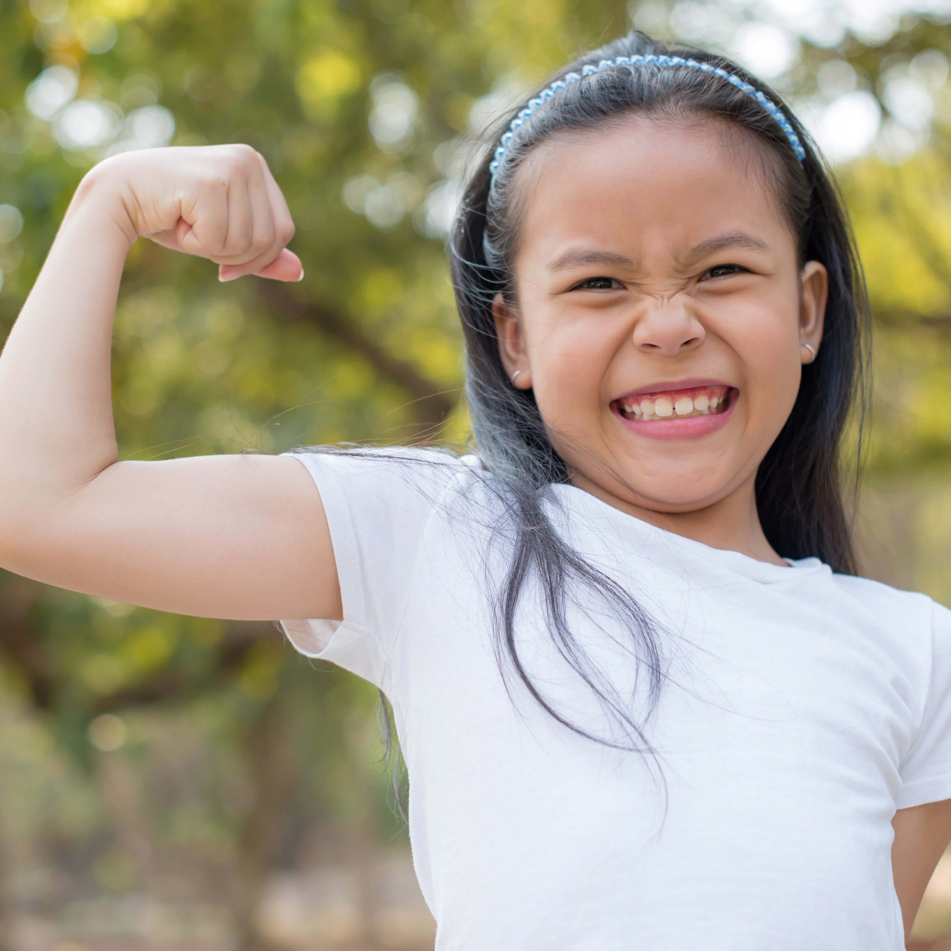 Young girl flexing arm muscles | The Good and the Beautiful Blog