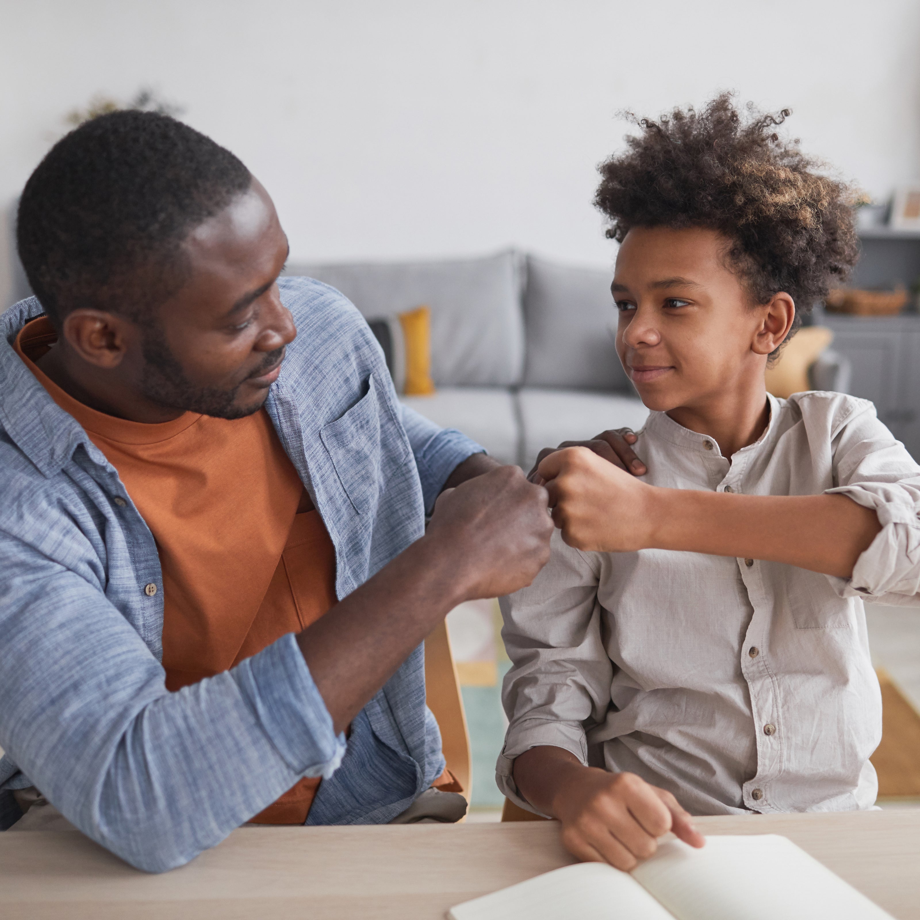 A school-aged boy fist bumping his dad | The Good and the Beautiful