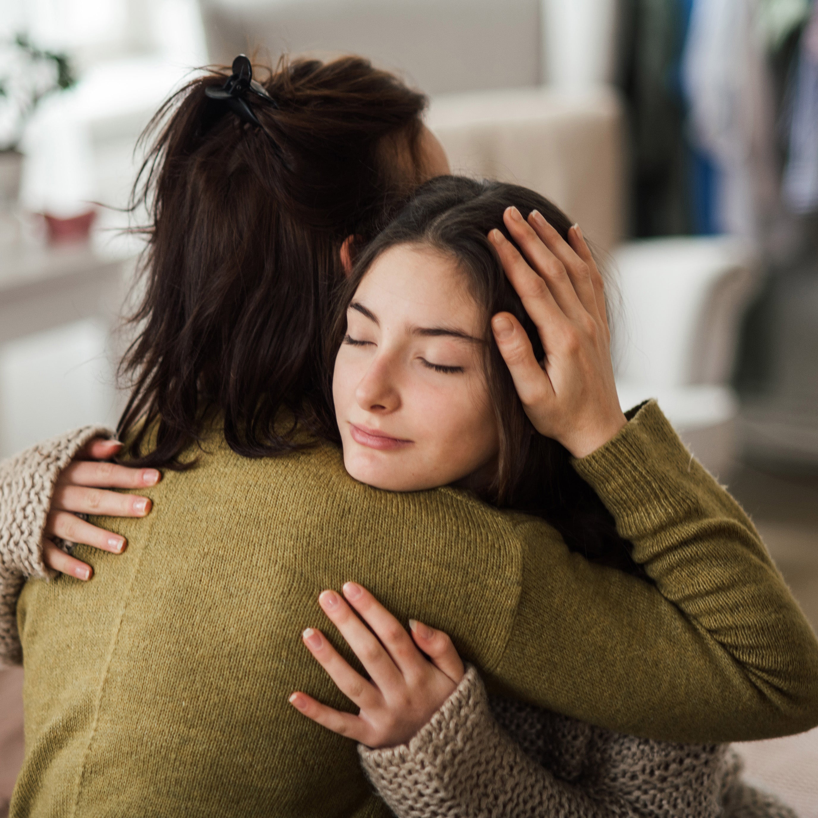 Mother and daughter hugging in a cozy living room setting