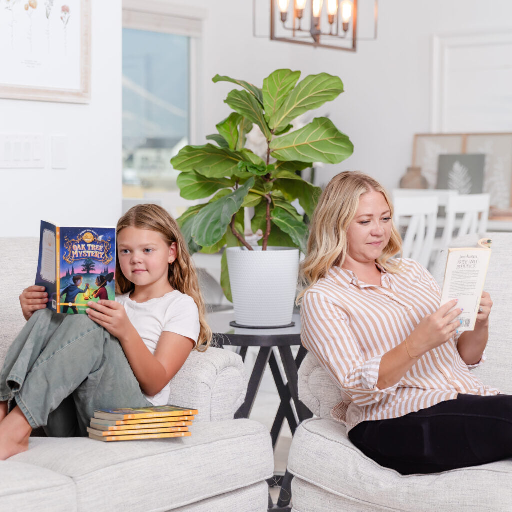 A school-aged girl and her mom sitting on couches reading books from the Badger Hills Farm series | The Good and the Beautiful 