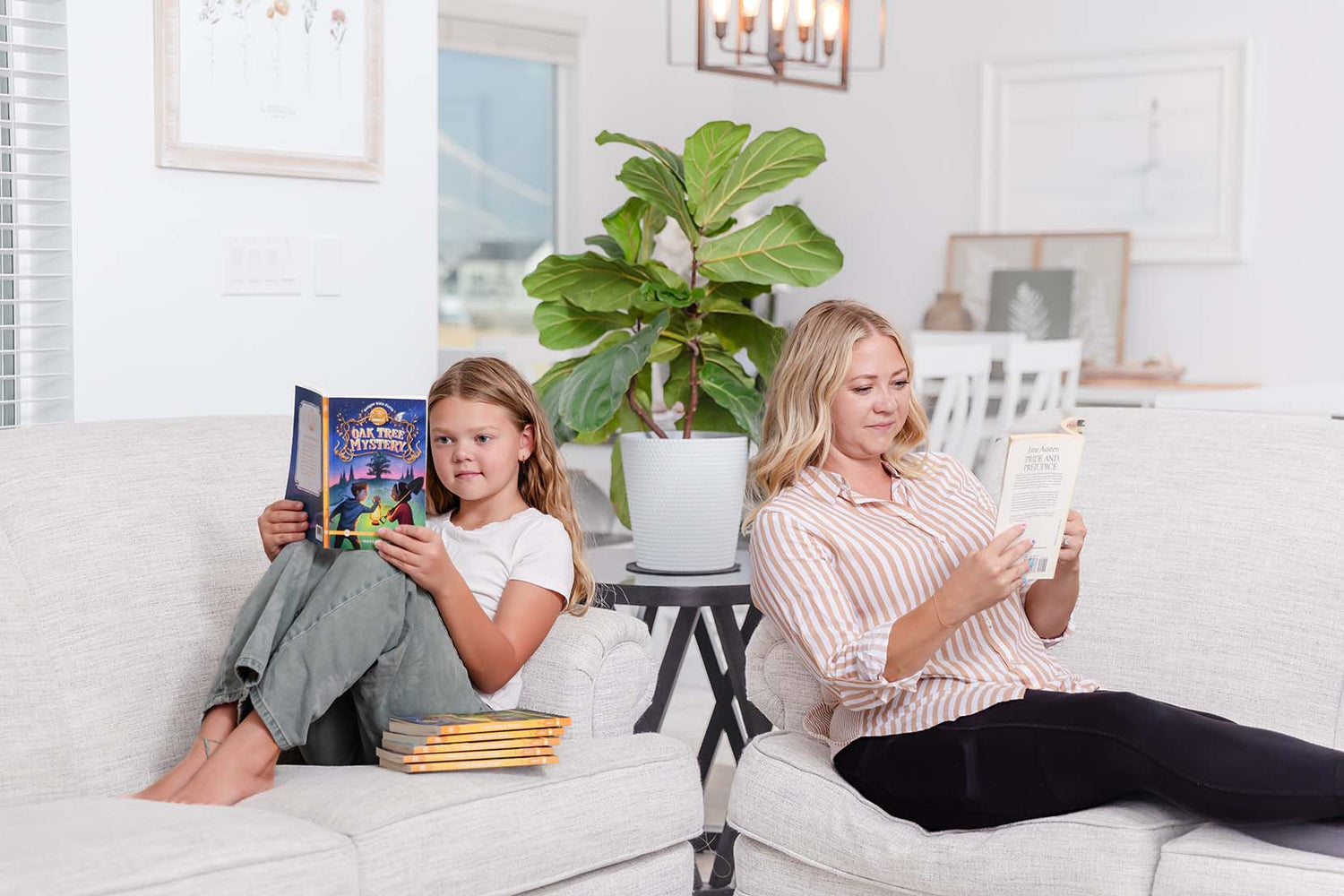 A mother and daughter sitting on separate couches while reading books | The Good and the Beautiful