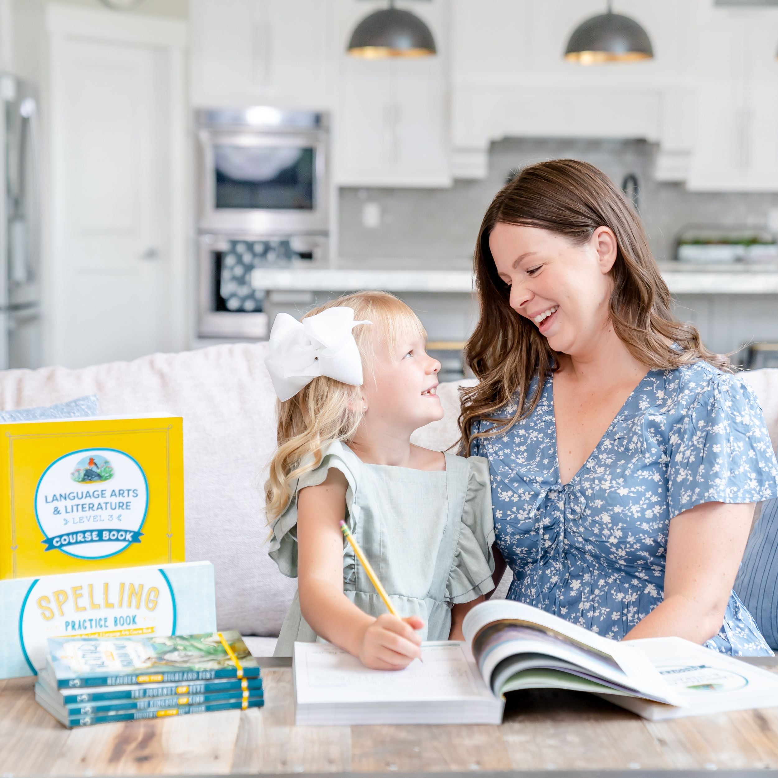 A school-aged girl writing in the language arts level 3 course book as she looks up and smiles at her mom | The Good and the Beautiful