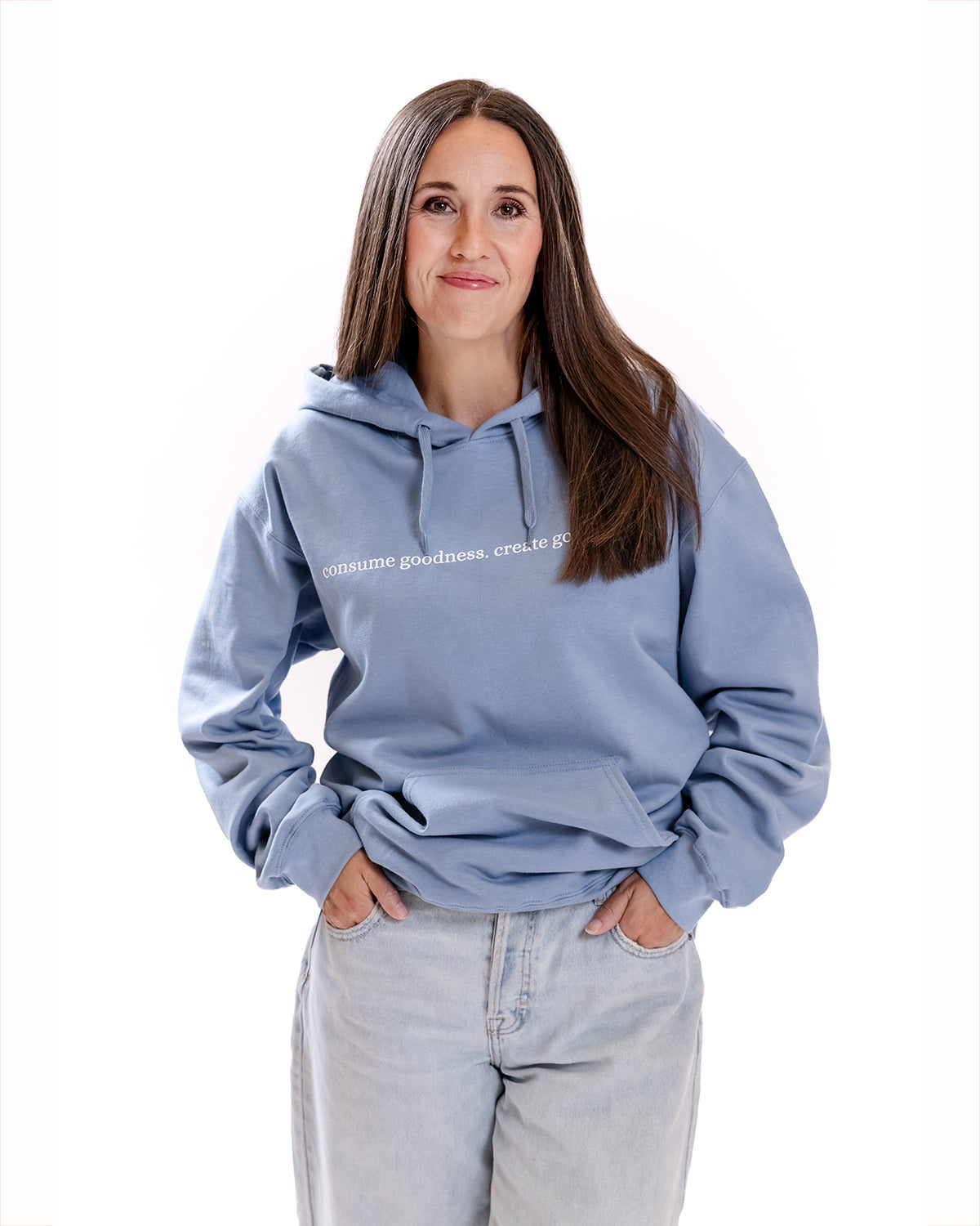 A woman modeling a hoodie that says "Consume Goodness, Create Goodness" | The Good and the Beautiful