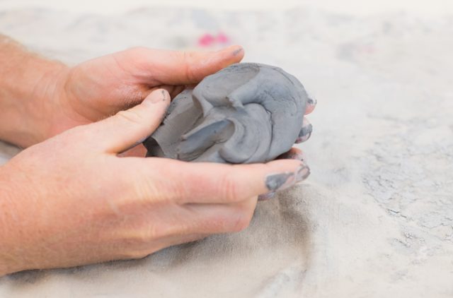 Photograph of Two Hands Working with Clay