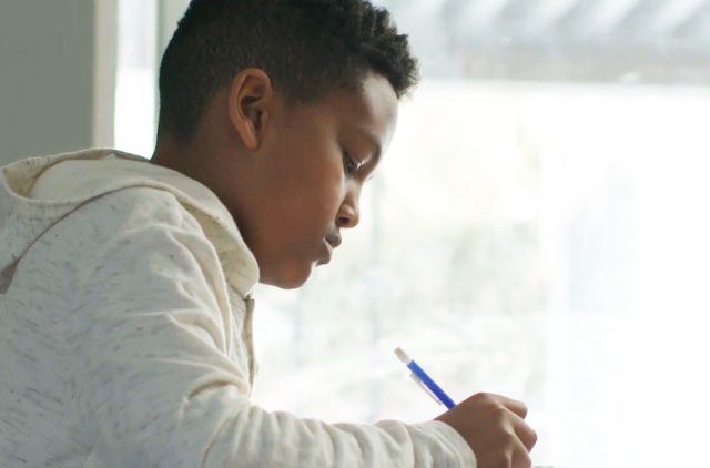 Photograph of a Boy Holding a Blue Pen