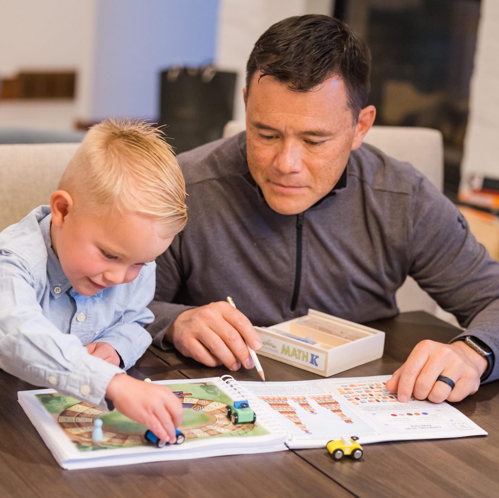 Photograph of dad and son working on math book