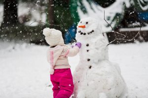 Young Girl building a snowman