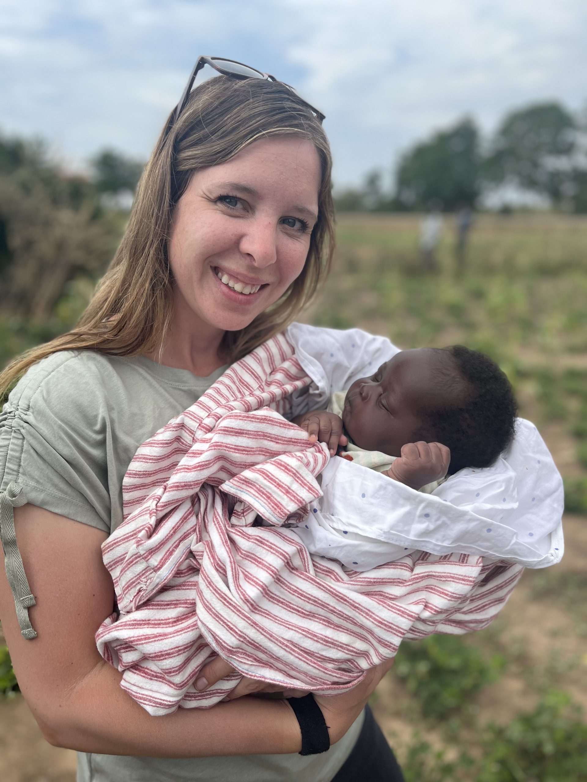 Photograph of woman holding African Baby wrapped in blankets