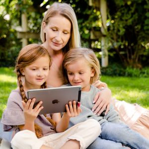 Lifestyle photo mom with two daughters and ipad